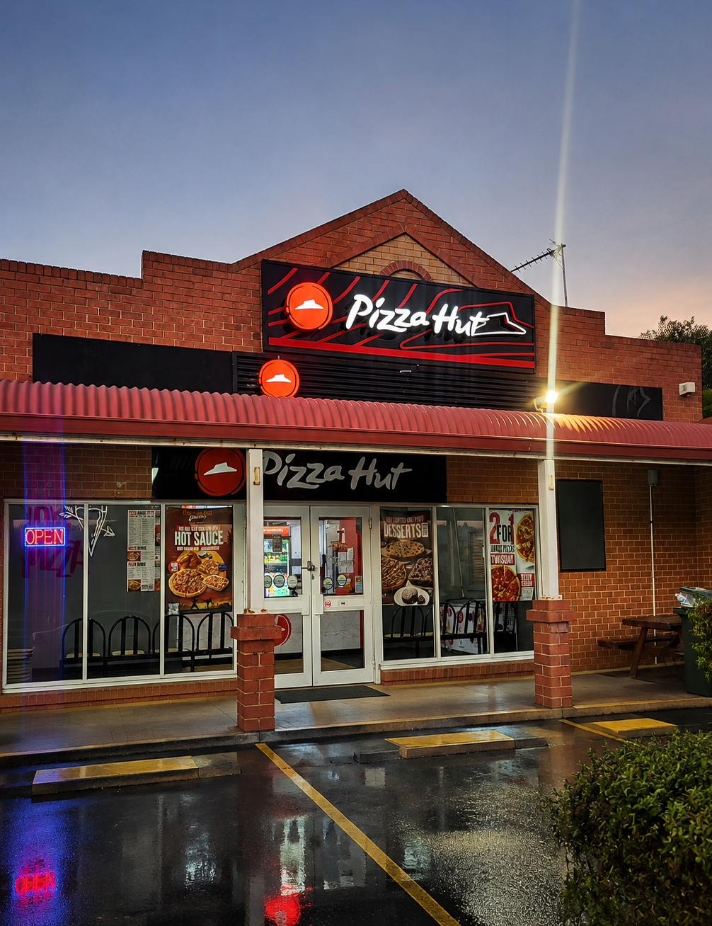 Pizza Hut restaurant exterior featuring illuminated signage at night